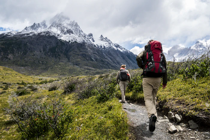 Deux personnes marchant vers une montagne enneigée
