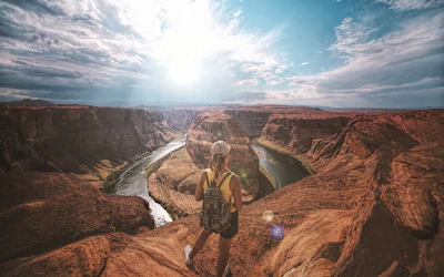 Voyageuse face au méandre d'un canyon